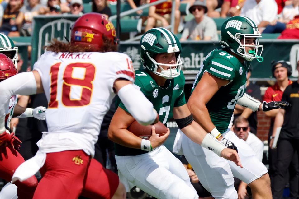 Ohio quarterback Kurtis Rourke, center, runs between Iowa State defensive back Ben Nikkel, left, and Ohio tight end Will Kacmarek during an NCAA college football game Saturday, Sept. 16, 2023 in Athens, Ohio. (AP Photo/Paul Vernon)