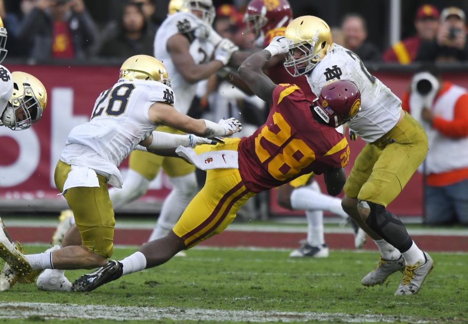 Notre Dame safety Nicco Fertitta, left, puts a hit on USC's Aca'Cedric Ware, center. Fertitta was ejected from the game after being called for targeting on the play. (AP Photo/Mark J. Terrill)