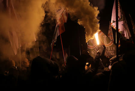 Demonstrators light flares during a protest against a proposed new labor law, billed as the "slave law", outside the headquarters of the Hungarian state television in Budapest, Hungary, December 17, 2018. REUTERS/Marko Djurica