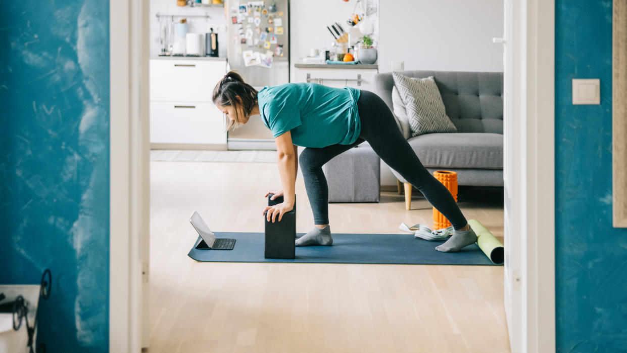  Woman learning how to use yoga blocks by watching onl 