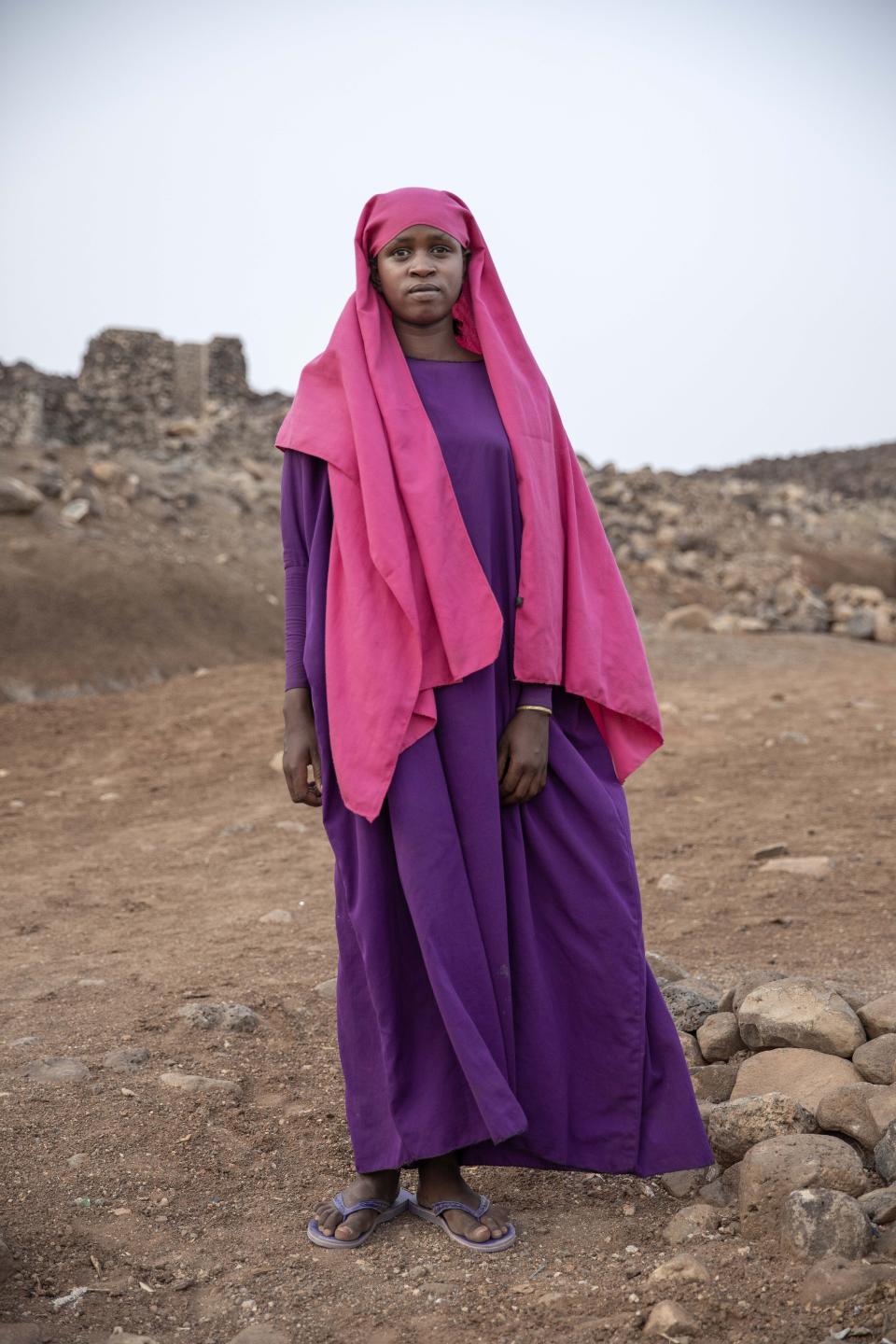 In this July 12, 2019 photo, 17-year-old Ikram Abdi, a migrant from Ethiopia, poses for a portrait in a slum area of Dikhil, Djibouti. Like many of the migrants, she left at dawn without her families' knowledge and hoped for their forgiveness when she starts sending them money from Saudi. (AP Photo/Nariman El-Mofty)