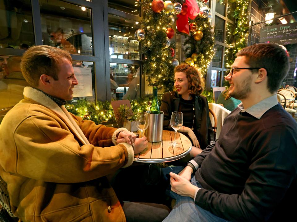 Revellers enjoy a drink ahead of New Year's Eve celebrations at a bar in Soho, central London. (James Manning/PA)