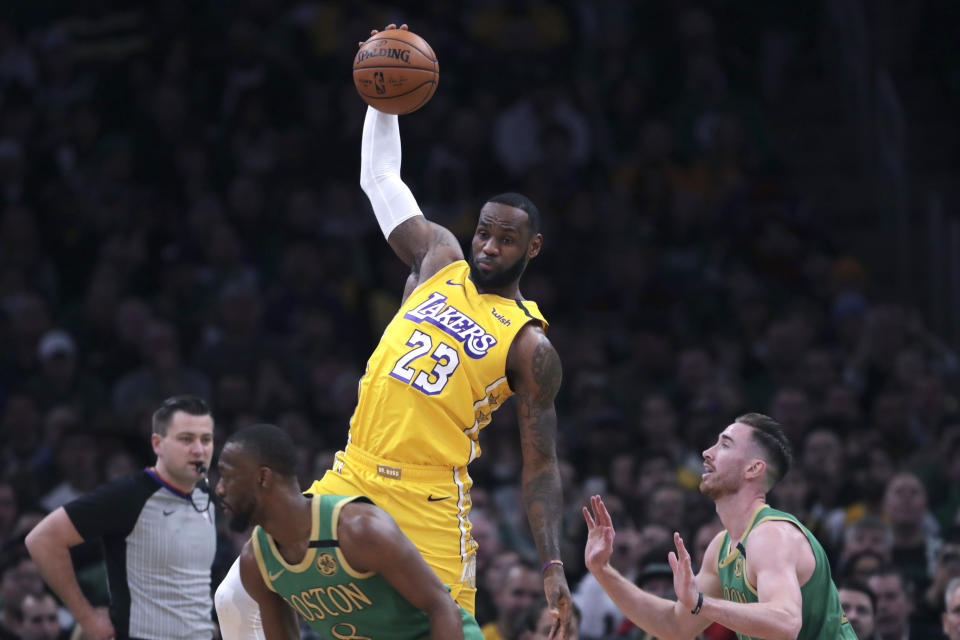 Los Angeles Lakers forward LeBron James (23) leaps for a pass as he is covered by Boston Celtics forward Gordon Hayward (20) during the first half of an NBA basketball game in Boston, Monday, Jan. 20, 2020. (AP Photo/Charles Krupa)