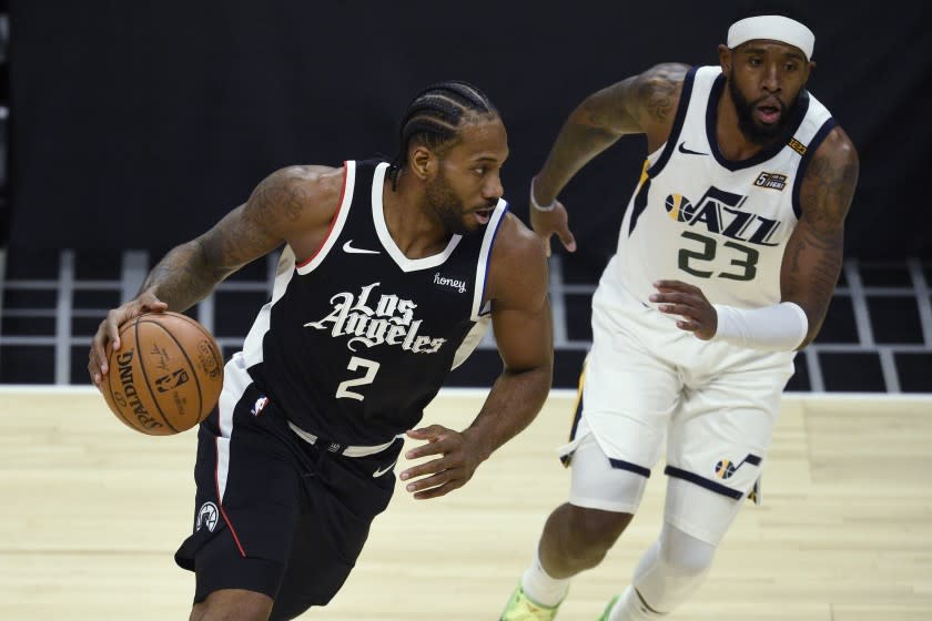 Los Angeles Clippers forward Kawhi Leonard, left, is defended by Utah Jazz forward Royce O'Neale.