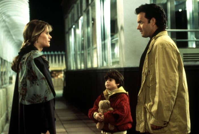 A man and a woman meet for the first time as a child holding a stuffed toy looks on