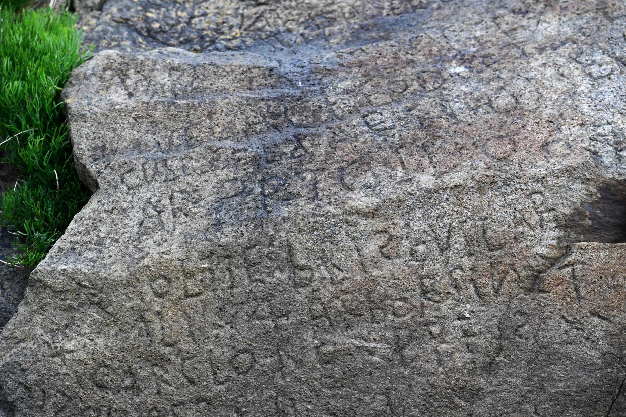 This picture taken on May 7, 2019 shows inscriptions composing indecipherable words on a rock in the Brittany village of Plougastel-Daoulas. The city launched a national call with a 2000 euros reward to anyone able to solve the mystery of those inscriptions probably made during the 18th century. (Photo by FRED TANNEAU/AFP/Getty Images)