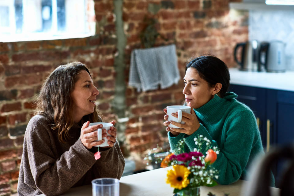 Female friends sitting in cafe with mug of coffee, talking, support, friendship