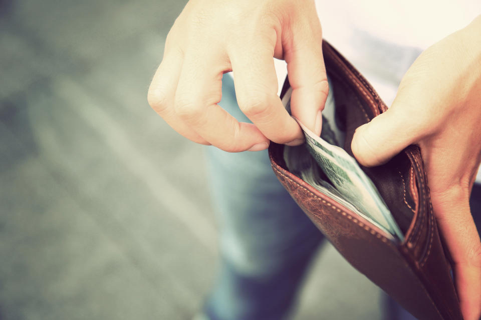 Person pulling money out of a wallet.