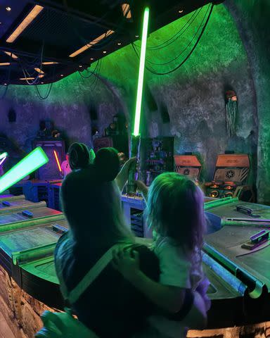 <p>Instagram/praisethelourd</p> Billie Lourd and her daughter hold a lightsaber together.