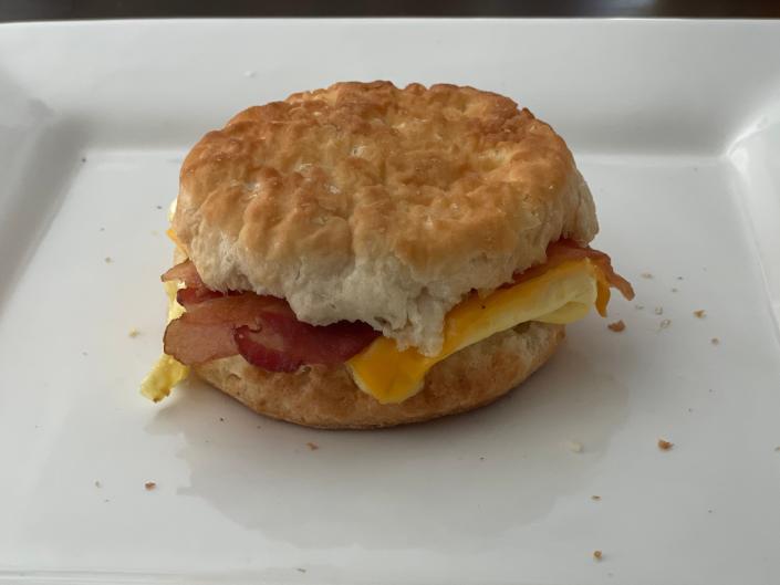 Breakfast sandwich of egg, cheese, and bacon between a biscuit