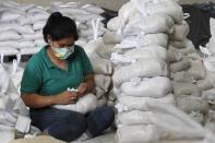 A volunteer packs rice inside a Department of Social Welfare and Development warehouse before shipping them out to the devastated provinces hit by Typhoon Haiyan in Manila November 8, 2013. Typhoon Haiyan, the strongest typhoon in the world this year and possibly the most powerful ever to hit land battered the central Philippines on Friday, forcing millions of people to flee to safer ground, cutting power lines and blowing apart houses. Haiyan, a category-5 super typhoon, bore down on the northern tip of Cebu Province, a popular tourist destination with the country's second-largest city, after lashing the islands of Leyte and Samar with 275 kph (170 mph) wind gusts and 5-6 meter (15-19 ft) waves. REUTERS/Romeo Ranoco (PHILIPPINES - Tags: DISASTER ENVIRONMENT)