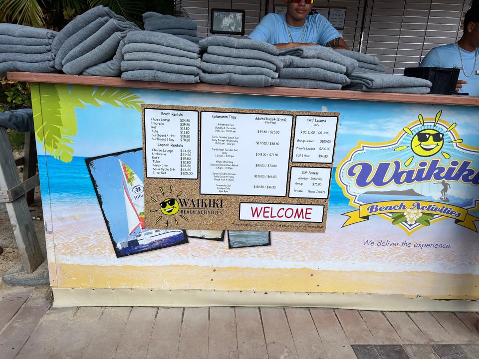 A stand with towels and prices for beach rentals.