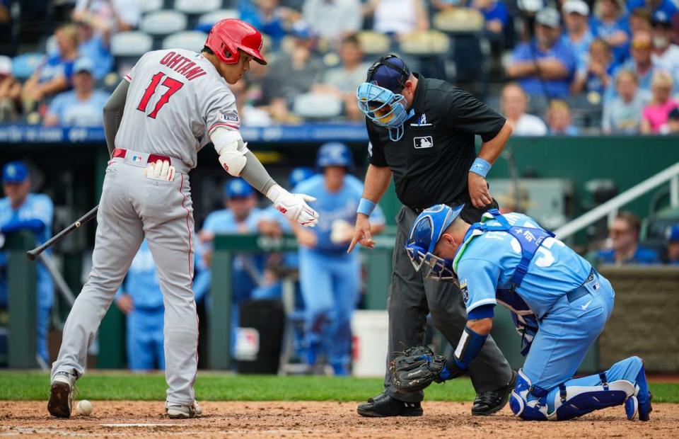 Angels designated hitter Shohei Ohtani, left, checks on Royals catcher Freddy Fermin after hitting him on a swing during the fifth inning of Sunday’s game at Kauffman Stadium.