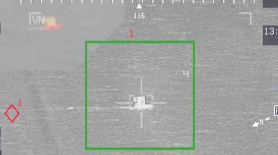 A screenshot from a US Marine Corps video showing a grey targeting screen, with a sea vessel in the middle.