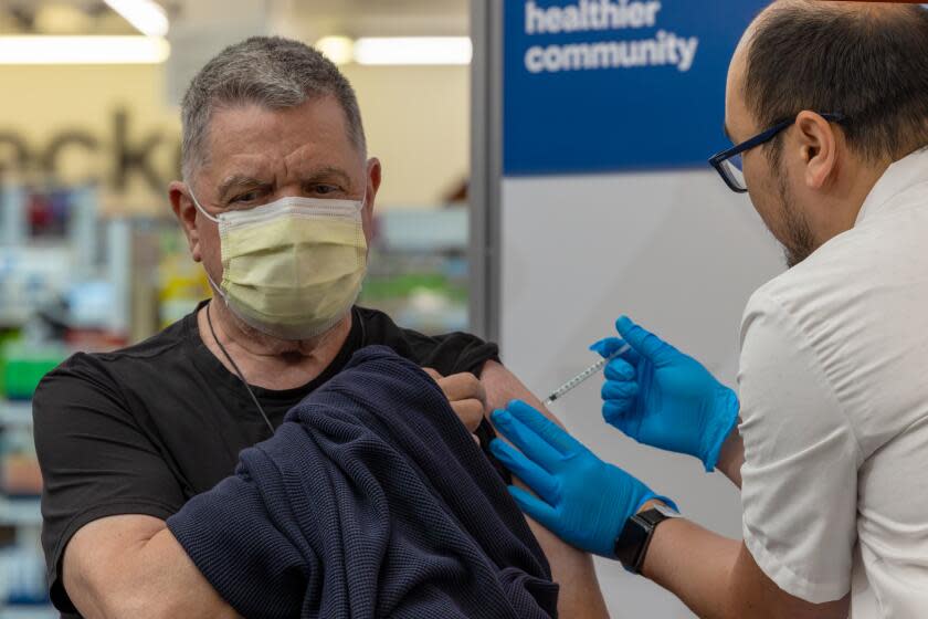 EAGLE ROCK, CA - SEPTEMBER 14: Pharmacist Aaron Sun administers new vaccine COMIRNATY® (COVID-19 Vaccine, mRNA) by Pfizer, to John Vuich at CVS Pharmacy in Eagle Rock, CA. (Irfan Khan / Los Angeles Times)