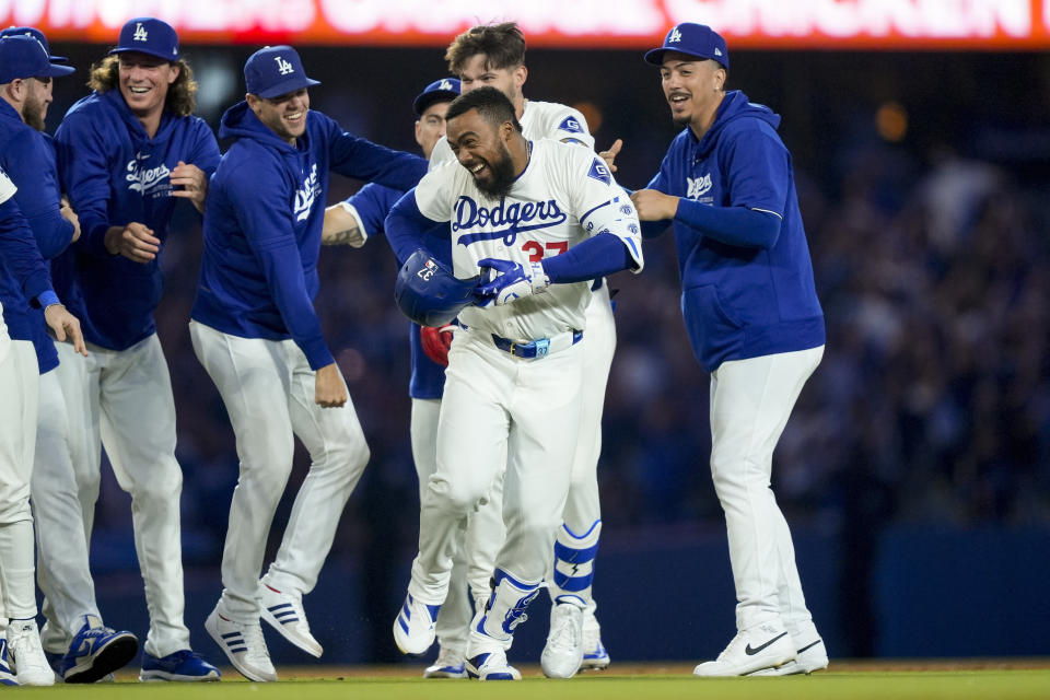 Los Angeles Dodgers' Teoscar Hernandez, center, celebrates with teammates after hitting a walk-off single to score Freddie Freeman during the ninth inning of a baseball game against the Arizona Diamondbacks, Tuesday, July 2, 2024, in Los Angeles. (AP Photo/Ryan Sun)