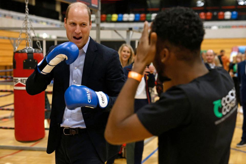 William (L), Prince of Wales, trains in boxing gloves during a visit to Copper Box Arena to celebrate the 10th anniversary of Coach Core in London