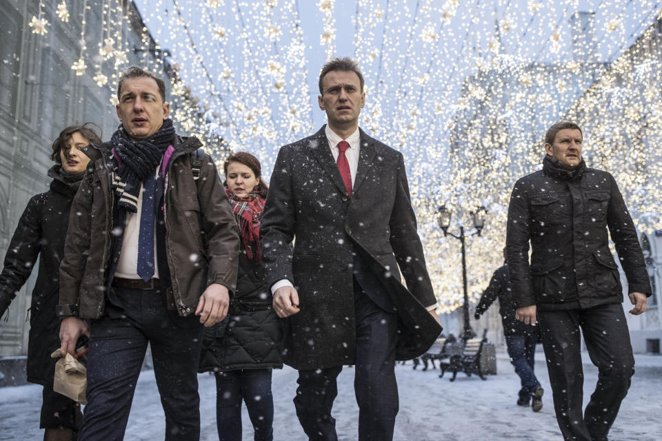 FILE - Russian opposition leader Alexei Navalny, who submitted endorsement papers necessary for his registration as a presidential candidate, center, heads to attend a meeting in the Russia's Central Election commission in Moscow, Russia, on Monday, Dec. 25, 2017. In a span of a decade, Navalny has gone from the Kremlin's biggest foe to Russia's most prominent political prisoner. Already serving two convictions that have landed him in prison for at least nine years, he faces a new trial that could keep him behind for another two decades. (AP Photo/Evgeny Feldman, File)