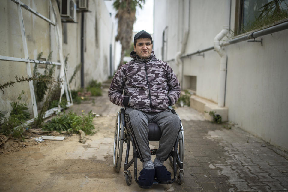 Khaled Benneejma, 32, a protester who was paralyzed after being shot during Tunisia's democratic uprising 10 years ago, poses for a portrait in Tunis, Tunisia, Tuesday, Jan. 12, 2021. (AP Photo/Mosa'ab Elshamy)