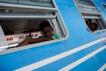 Irial Preval peers from a window inside a new Cuba's Chinese-made passenger train car before departing from La Coubre train station in Havana