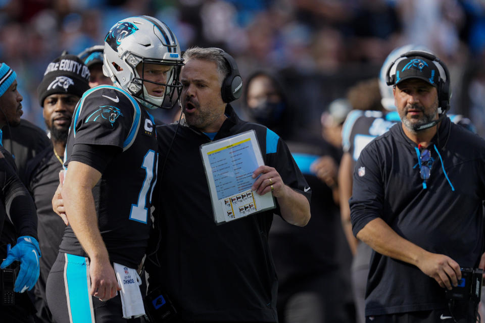 Carolina Panthers head coach Matt Rhule talks with quarterback Sam Darnold during the first half of an NFL football game against the Tampa Bay Buccaneers Sunday, Dec. 26, 2021, in Charlotte, N.C. (AP Photo/Jacob Kupferman)