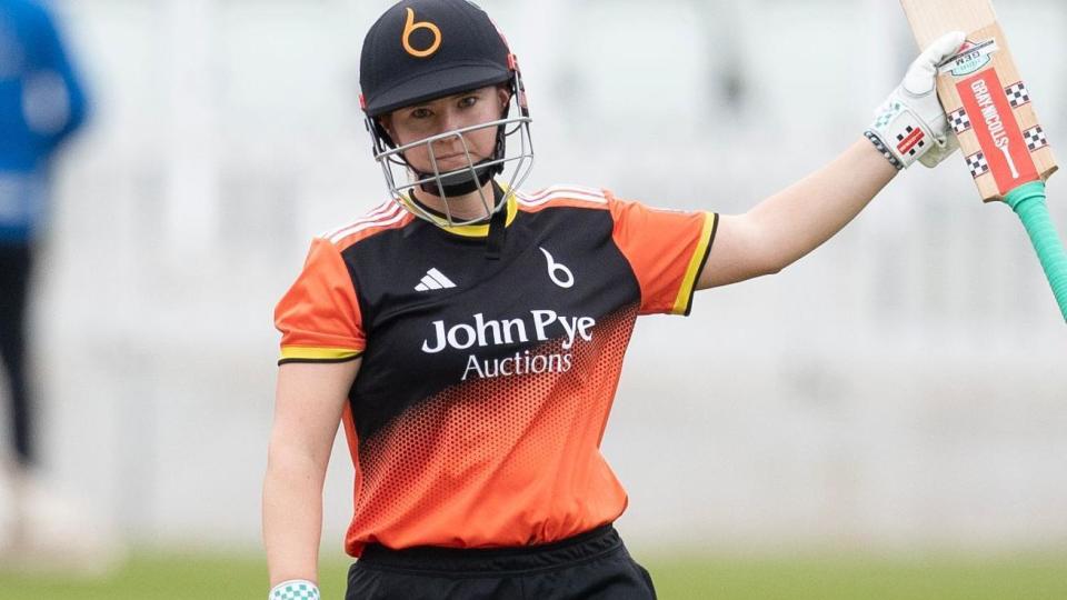 Kathryn Bryce raises her bat at Lord's to acknowledge reaching 50