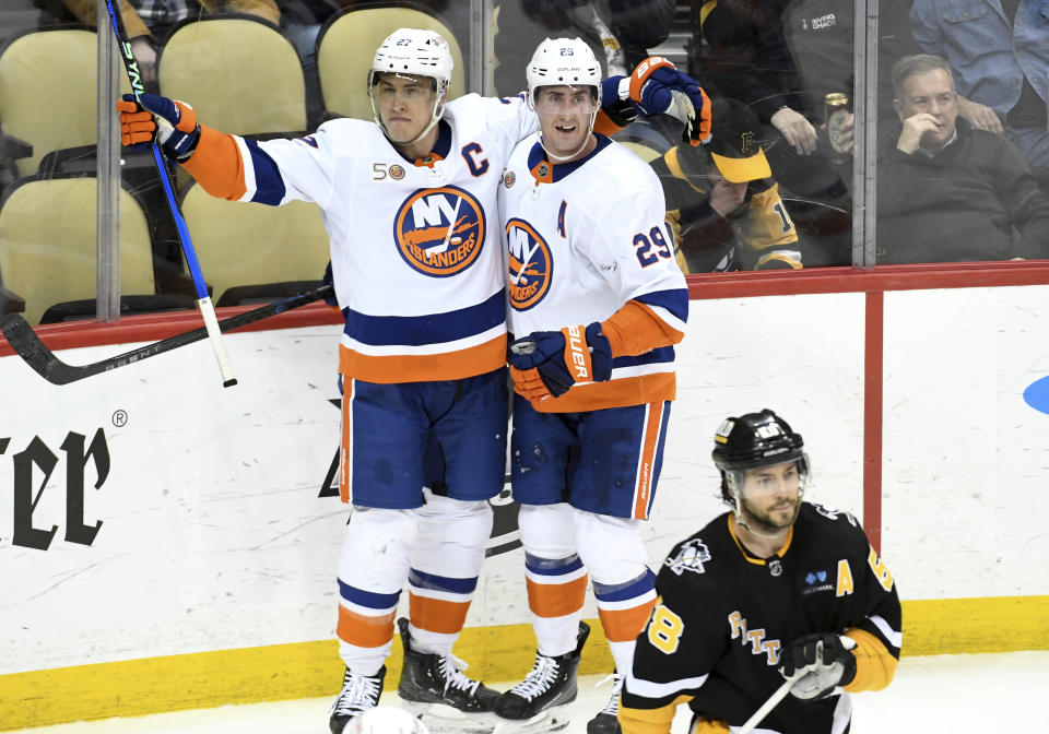 New York Islanders Anders Lee (27) celebrates a goal with center Brock Nelson (29) as Pittsburgh Penguins defenseman Kris Letting (58) skates by during the third period of an NHL hockey game, Thursday, March 9, 2023, in Pittsburgh. The Islanders won 4-3. (AP Photo/Philip G. Pavely)