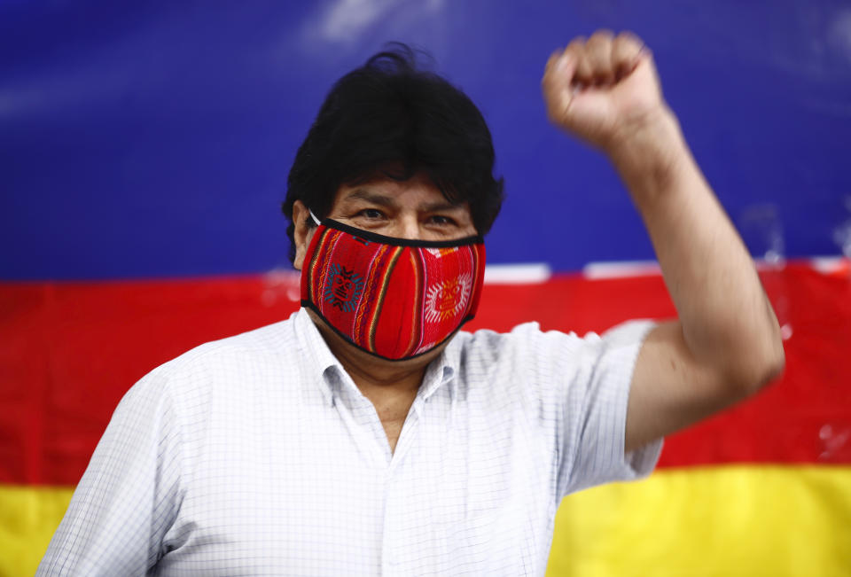 Former Bolivian President Evo Morales raises his fist as he arrives for a press conference at Movement Towards Socialism (MAS) headquarters in Buenos Aires, Argentina, during general elections in his home country, Sunday, Oct. 18. 2020. (AP Photo/Marcos Brindicci)