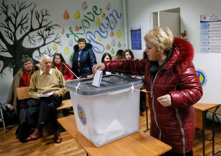 A woman casts a ballot during a presidential election at a polling station in Chisinau, Moldova, October 30, 2016. REUTERS/Gleb Garanich