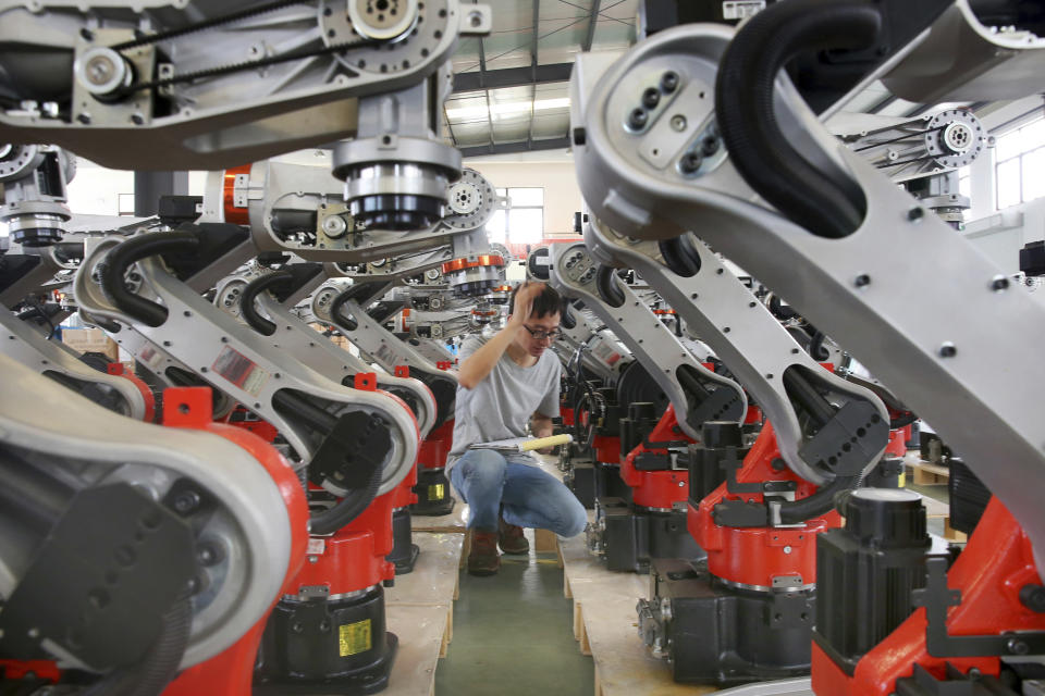 In this Wednesday, Sept. 11, 2019, photo, a man checks on the robotic arms at a factory making industrial robots in Zhengyu town of Haimen city in east China's Jiangsu province. A Chinese envoy is going to Washington on Wednesday, Sept. 18, to prepare for trade negotiations. The announcement Tuesday, Sept. 17, follows conciliatory gestures by both sides ahead of the October talks on their fight over trade and technology, which threatens to dampen global economic growth. (Chinatopix via AP)