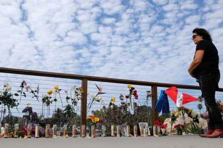 A woman pauses to look over a makeshift memorial near Truth Aquatics as the search continues for those missing in a pre-dawn fire that sank a commercial diving boat off a Southern California island near Santa Barbara, California