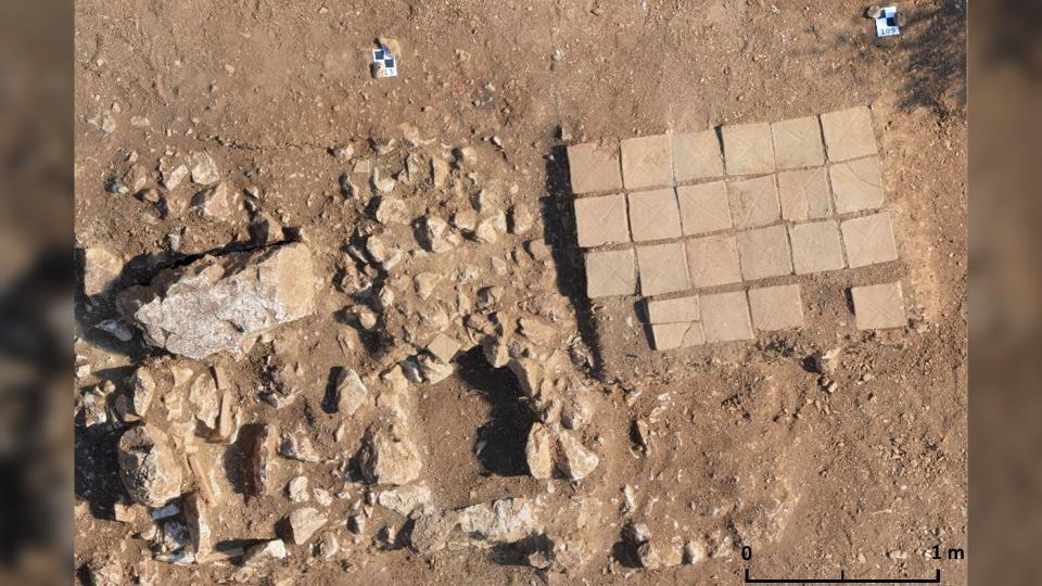 A photo of the cremation grave with bricks in place (right) next to two later tombs (left).