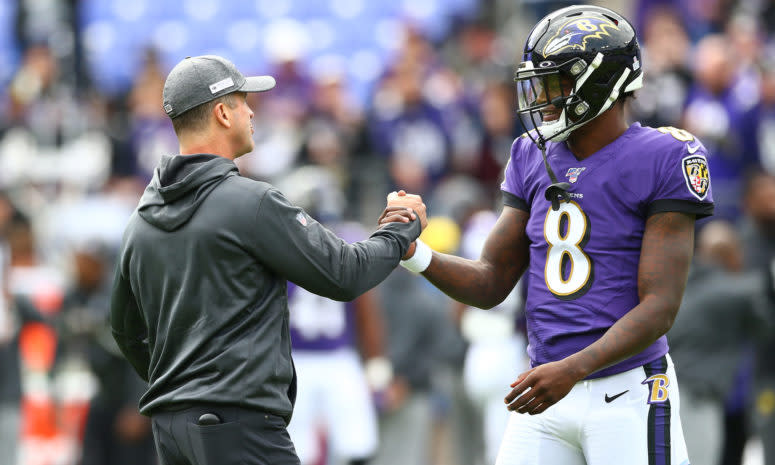 John Harbaugh and Lamar Jackson shake hands during Baltimore Ravens game.