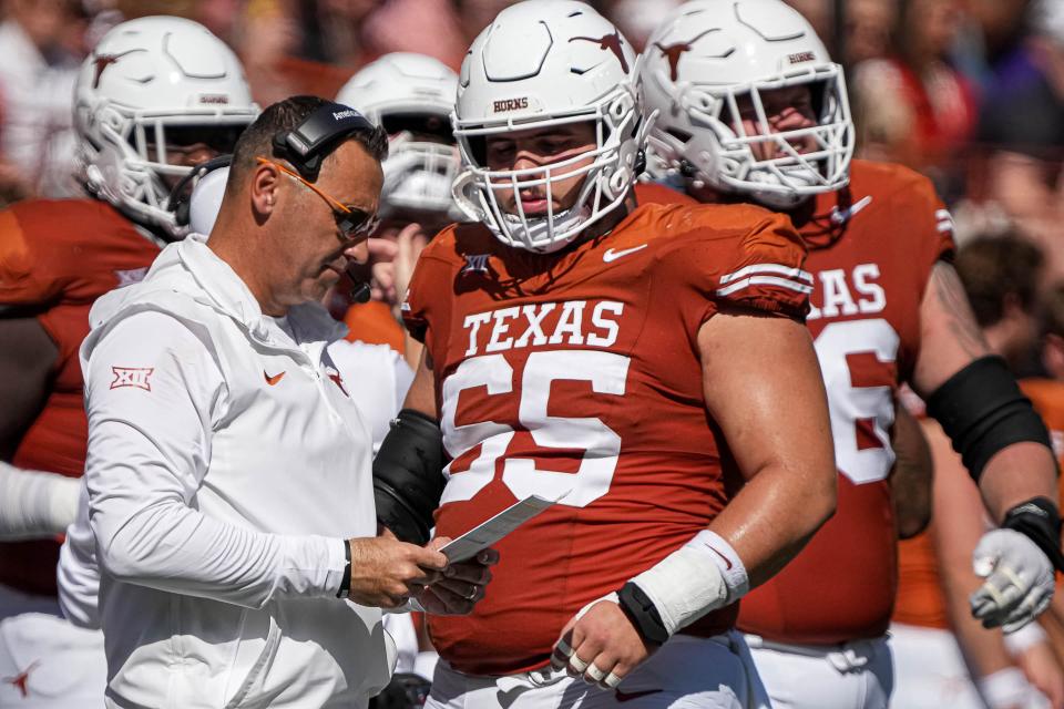 Texas Longhorns head coach Steve Sarkisian looks at his playbook with offensive lineman Jake Majors (65) during the game against Kansas State at Royal-Memorial Stadium on Saturday, Nov. 4, 2023 in Austin.