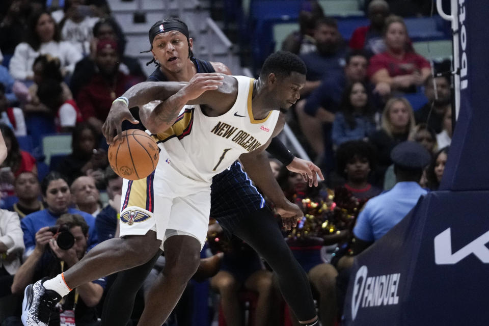 New Orleans Pelicans forward Zion Williamson (1) drives to the basket against Orlando Magic forward Paolo Banchero in the first half of an NBA preseason basketball game in New Orleans, Tuesday, Oct. 10, 2023. (AP Photo/Gerald Herbert)