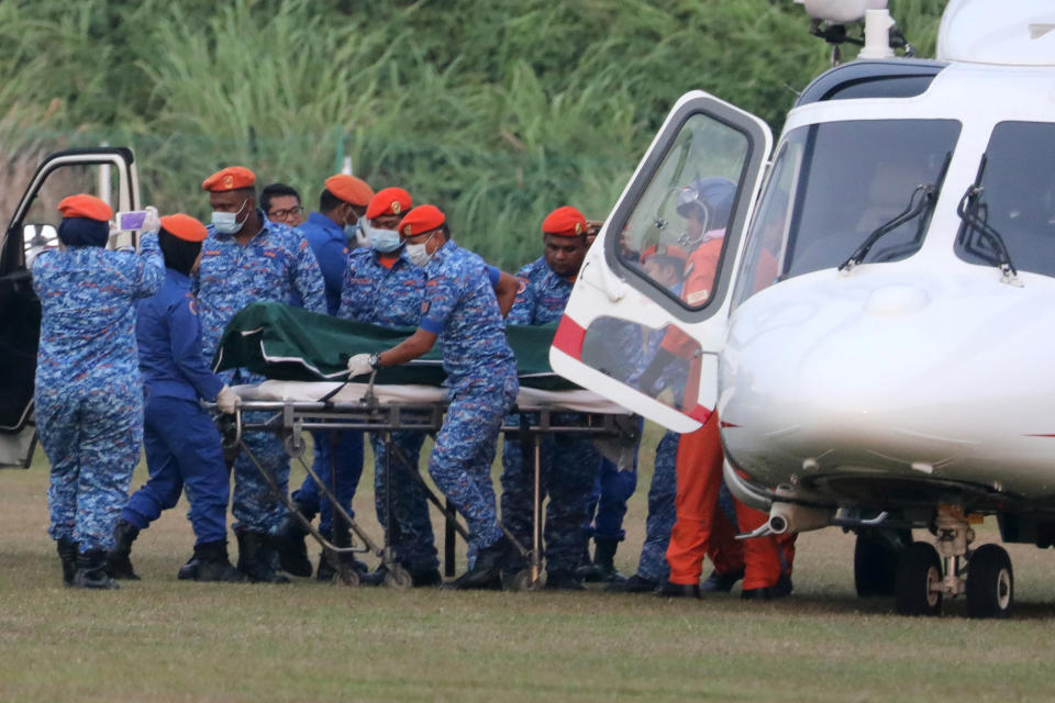 The body of the 15-year-old British schoolgirl who went missing is brought out of a helicopter in Seremban.