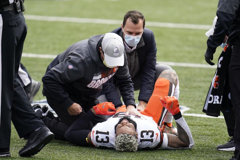 Cleveland Browns' Odell Beckham Jr. (13) is examined during the first half of an NFL football game against the Cincinnati Bengals, Sunday, Oct. 25, 2020, in Cincinnati. Browns star wide receiver Odell Beckham Jr. will miss the rest of the season after tearing a knee ligament during Sunday's 37-34 win at Cincinnati. (AP Photo/Michael Conroy)