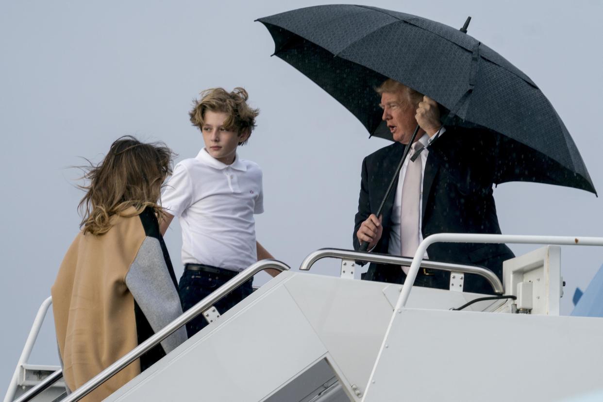 Donald, Barron und Melanie Trump wurden am Palm Beach International Airport vom Regen überrascht. (Bild: AP Photo)