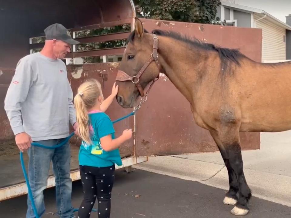 Shane Adams and his daughter greet Mongo, who was missing for eight years.
