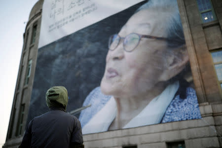 A man looks at a giant banner bearing a portrait of a former South Korean "comfort woman" Kim Bok-dong during her funeral in Seoul, South Korea, February 1, 2019. REUTERS/Kim Hong-Ji