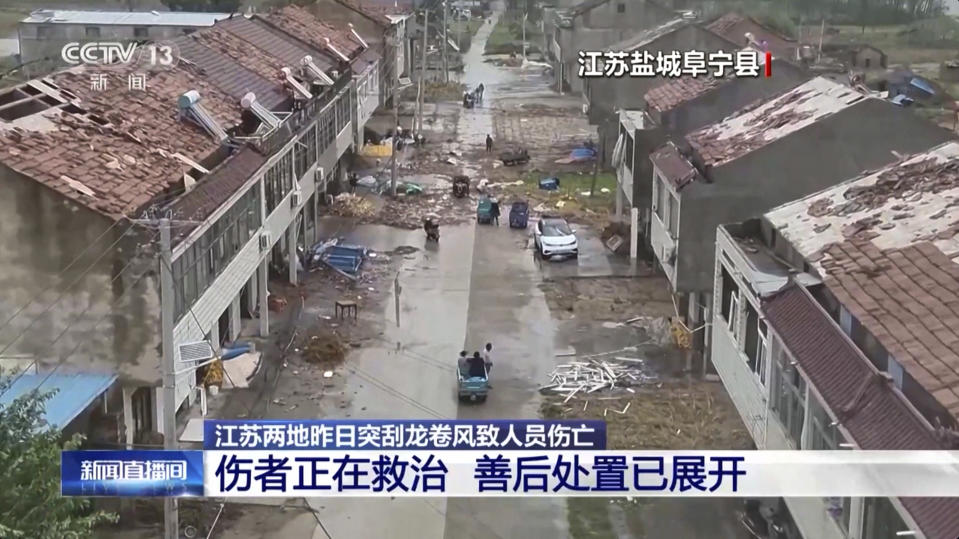 In this image taken from video footage run by China's CCTV, villagers walk by damaged houses in the aftermath of a tornado swept through in Yancheng city in eastern China's Jiangsu Province on Tuesday, Sept. 19, 2023. Two tornadoes within hours killed and injured several people in eastern China, state media said Wednesday. (CCTV via AP)