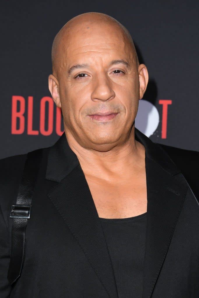 Vin Diesel on the red carpet wearing a black suit with a black undershirt at the premiere of 