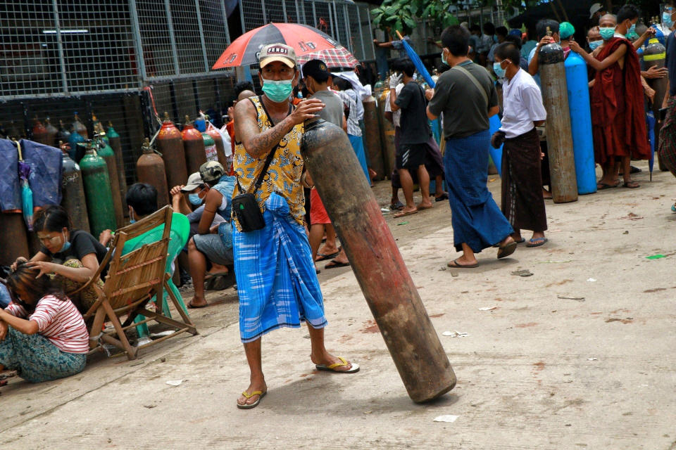 A man holds an oxygen tank while waiting outside the Naing oxygen factory at the South Dagon industrial zone in Yangon, Myanmar, Wednesday, July 28, 2021. Myanmar is currently reeling from soaring numbers of COVID-19 cases and deaths that are badly straining the country’s medical infrastructure. (AP Photo)