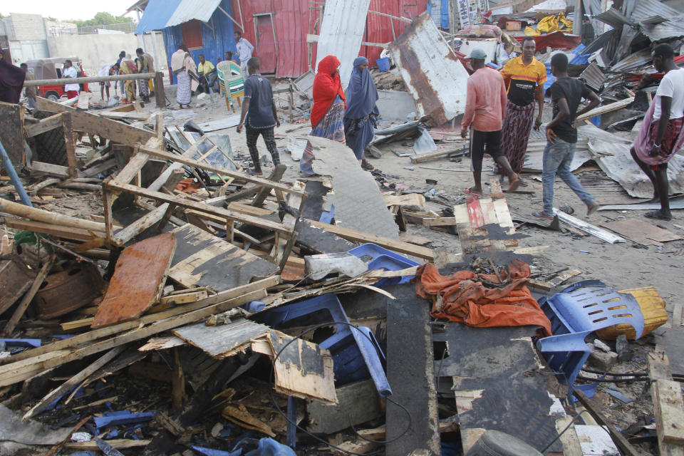 People look at destroyed shops in Mogadishu's Lido beach, Somalia, Saturday, April, 23, 2022, after a bomb blast by Somalia’s Islamic extremist rebels hit a popular seaside restaurant killing at least six people. Ambulance service officials say the explosion occurred Friday evening when many patrons gathered for an Iftar meal to break the Ramadan fast. (AP Photo/Farah Abdi Warsameh)