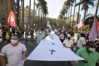 Demonstrators carry a banner with crosses on it during a protest against Brazil's President Jair Bolsonaro and his handling of the new coronavirus pandemic in Sao Paulo, Brazil, Friday, Aug. 7, 2020. Brazil is rapidly approaching 100,000 deaths related to COVID-19. (AP Photo/Andre Penner)