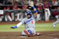 Los Angeles Dodgers' Miguel Rojas scores on a base hit by Shohei Ohtani during the eighth inning of a baseball game against the Arizona Diamondbacks, Monday, April 29, 2024, in Phoenix. (AP Photo/Matt York)