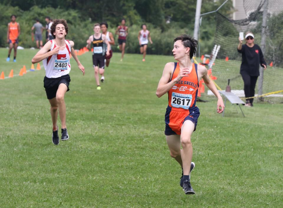 Ryan Sykes from Horace Greeley looks over his shoulder at Evan Bender from Fox Lane, as they approach the finish line during the boys D1 race at the Somers Big Red Invitational Cross Country meet at Somers High School, Sept. 9, 2023.