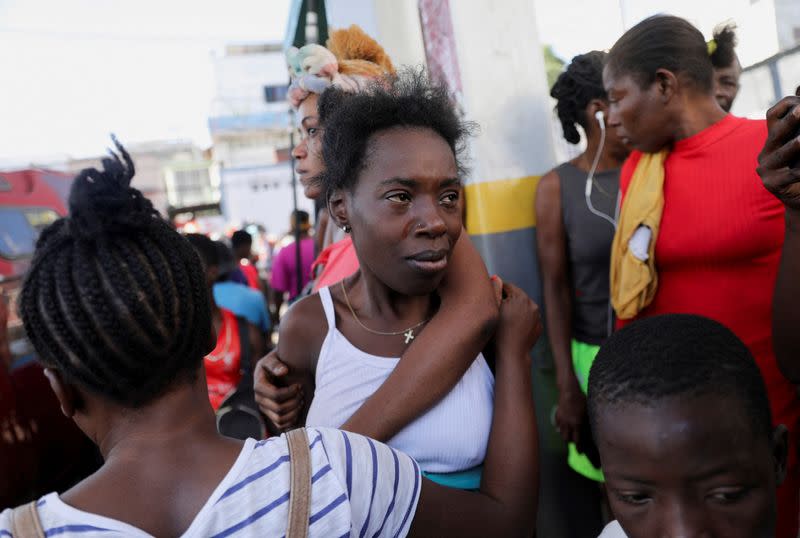 People react at a crime scene, in Port-au-Prince