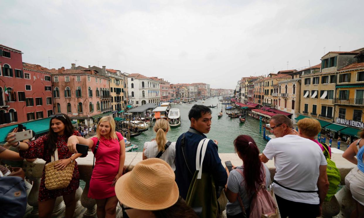 <span>Tourists on Rialto bridge, in Venice, Italy. Venice will begin charging day trippers to enter in an effort to protect the Unesco world heritage site from the effects of over-tourism.</span><span>Photograph: Luca Bruno/AP</span>