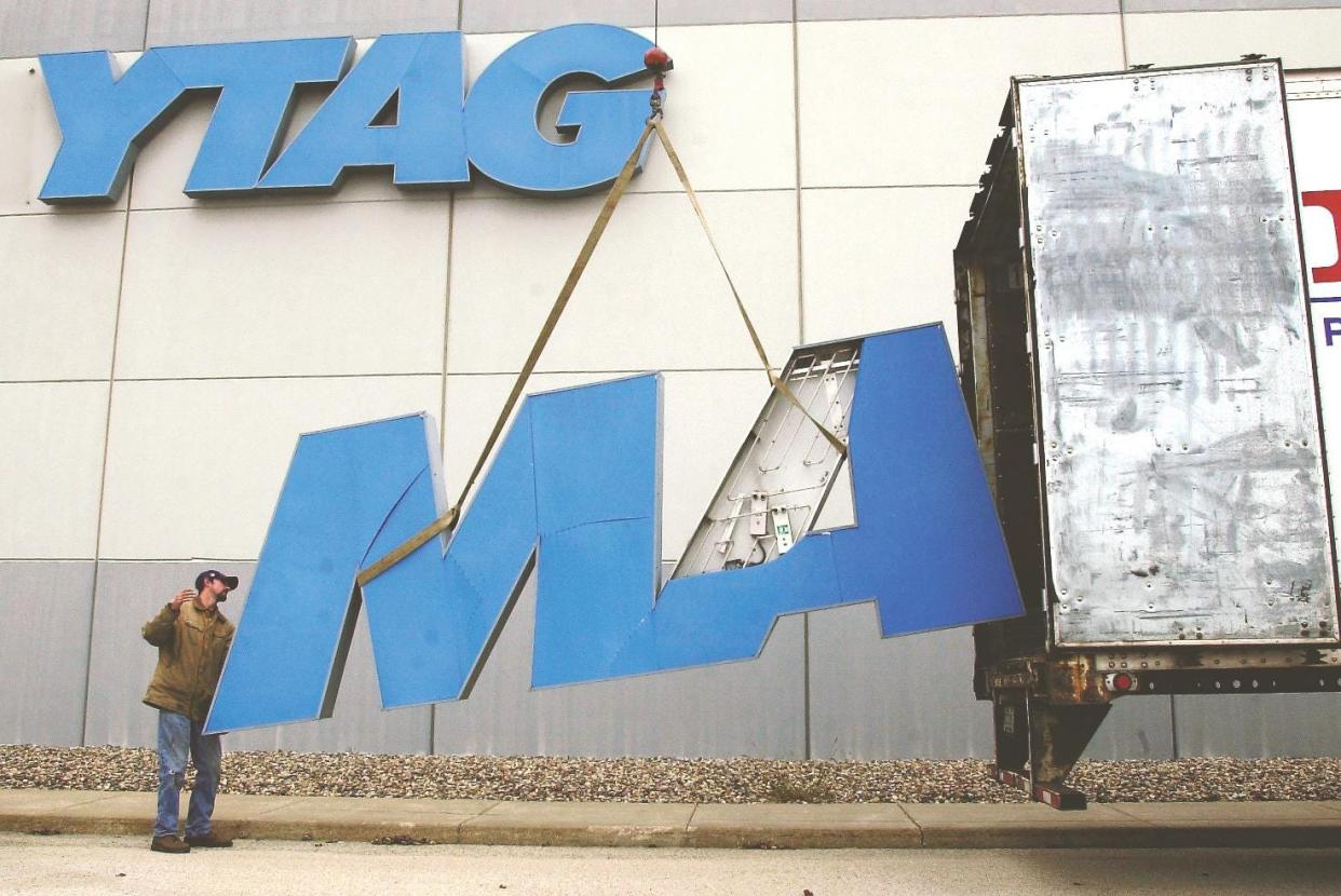 An employee of Galesburg Sign and Lighting Inc. attempts to load the first two letters of a Maytag sign into a trailer at the Galesburg plant along Monmouth Blvd. on Nov. 15, 2004.